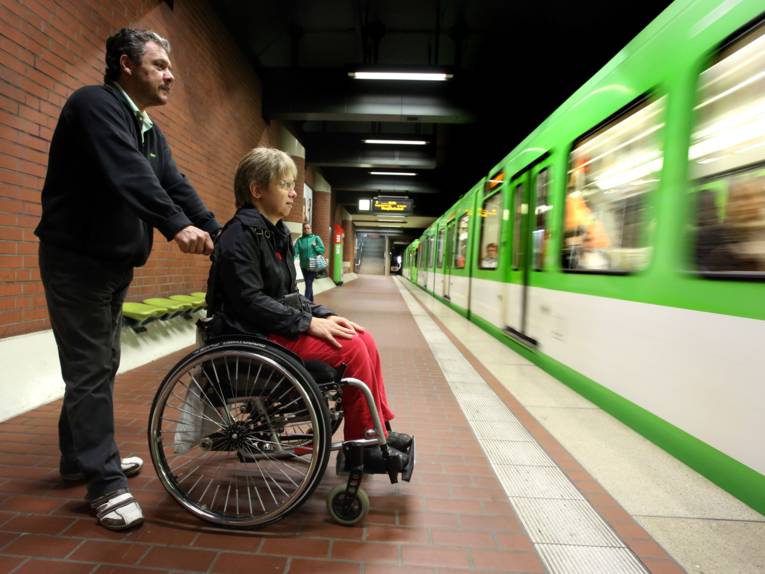 Der Fahrgastbegleiter begleitet die Rollstuhlfahrerin auf ihrer Fahrt mit der Stadtbahn.
